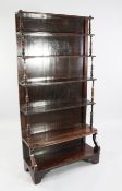 An early 19th century rosewood waterfall bookcase, with seven shelves and baluster uprights, on
