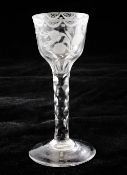 A hexagonal facetted stem wine glass, c.1790, the panelled ogee shaped bowl wheel engraved with