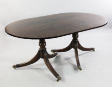 A Regency style mahogany and brass inlaid D end extending dining table, with one extra leaf, on