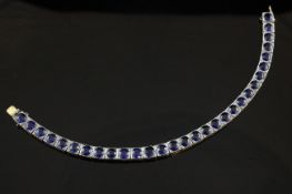 A 1940`s/1950`s gold and platinum, sapphire line bracelet, set with thirty round cut sapphires in a