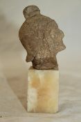 A Roman terracotta head of a soldier, c. 2nd century BC, 3in., on a later alabaster pedestal