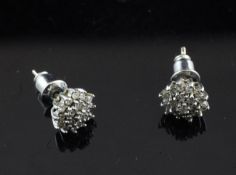 A pair of gold and diamond cluster ear studs.