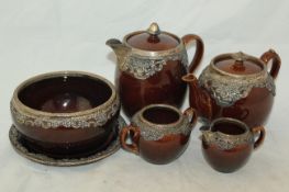 A Wedgwood treacle glazed pottery silver mounted part tea set, c.1906, the mounts with pierced and