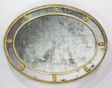 A 19th century Adam style oval gilt wall mirror, the central oval mirror plate glass with an outer