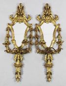 A pair of Italian carved giltwood girandoles, with cartouche shape mirror backs and twin scrolling