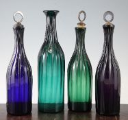 A set of three Victorian coloured glass decanters and a similar larger green glass decanter, each