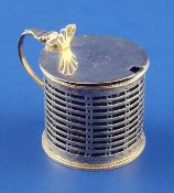 A George III pierced silver drum mustard, with engraved armorial and pierced shell thumbpiece,