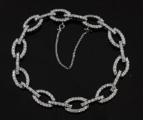 An 18ct white gold and diamond bracelet, with alternating oval and bar shaped links, approx. 7in.