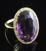 An 18ct gold, amethyst and diamond dress ring, the large oval cut amethyst bordered with rose cut
