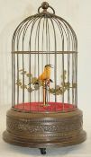 An early 20th century Swiss musical singing bird automaton, modelled as a yellow bird within domed