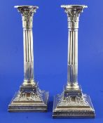 A pair of Edwardian silver corinthian column candlesticks, the base embossed with harebell swags,