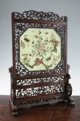 A Chinese hardstone and rosewood table screen, early 20th century, the inset hardstone panel relief