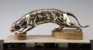 An Art Deco silvered metal statuette of a creeping tiger, mounted on a marble and onyx plinth base,