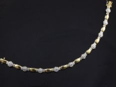 An 18ct gold bracelet set with ten diamond clusters of foliate design, gross 14 grams, 7.5in.