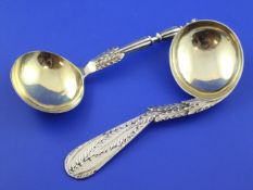 Two Victorian silver gilt spoons, one with turned fluted stem, the other with leaf stem and curved