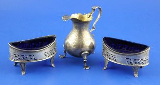 A pair of George III silver oval pierced salts with blue glass liners and a George II cream jug,