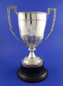 A Victorian silver two handled trophy cup, the body embossed with acanthus leaf decoration, on a