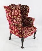 A George III oak framed wing back armchair, with fan carved cabriole legs and ball and claw feet