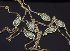 An early 20th century gold and plique a jour enamel guard chain, set with six shaped panels with