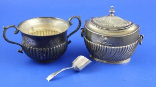 A Victorian demi wrythen fluted silver tea caddy, of oval form, with ring handles and embossed with