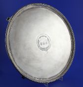 A George III silver circular salver, with later? engraved monogram and beaded borders, on four