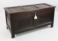 An 18th century oak coffer, with twin panelled front, on stile feet, W.4ft 6.5in.