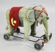 A 1950`s Steiff Zieh elephant pull-along mohair toy, wearing a red harness with a Turkish red flag