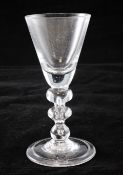 A heavy baluster goblet, c.1715, the round funnel bowl set on a teared angular and basal knopped
