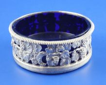 A George III pierced silver wine coaster with later blue glass liner, with fruiting vine decoration