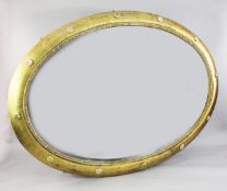 A large Victorian oval gilt framed wall mirror, the ovolo frame decorated with rosettes and with