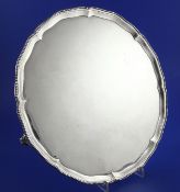 A George III silver salver, of shaped circular form, with beaded border, on three tapering shall