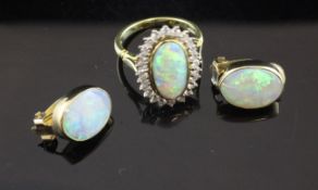 An 18ct gold, white opal and diamond dress ring, of oval form, the opal bordered with twenty four