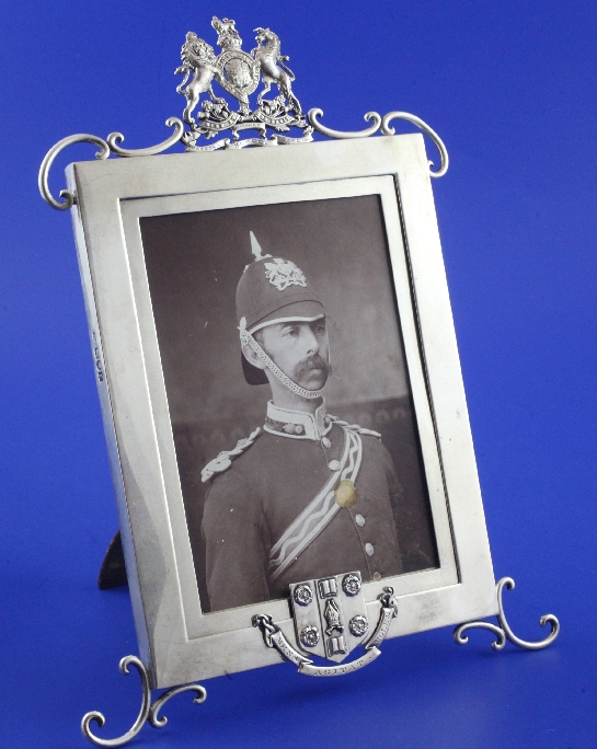 An Edwardian military related silver photograph frame, of rectangular form, decorated with the