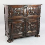 A late 17th century oak cabinet, with deep single drawer above two cupboard doors, with geometric