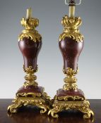 A pair of Louis XV style rouge marble and ormolu mounted table lamps, each with an inverted pear