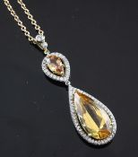 A gold, topaz and diamond set drop pendant, the two graduated pear shaped topaz with a total weight