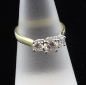 An 18ct gold and three stone diamond ring, with an estimated total diamond weight of 1.00ct, size