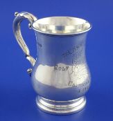 An Edwardian silver golfing related baluster mug, with acanthus leaf capped scroll handle and