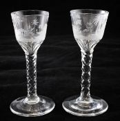 A pair of diamond-facetted stem wine glasses, c.1785, the panelled ogee shaped bowls wheel engraved