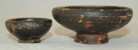 Two Greek blackware salt cellars, Apulian c. 4th century BC, each of compressed globular form, on a