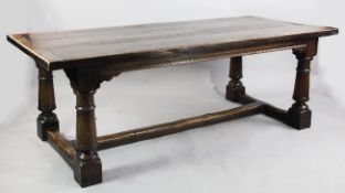 A 17th century style refectory table, the triple planked top with cleated ends and tapering barrel