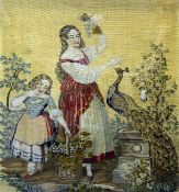 A large Victorian tapestry panel depicting two young girls with a peacock, in a gilt frame with