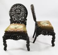 A pair of 19th century Indian carved and pierced rosewood side chairs, with arched back and drop in