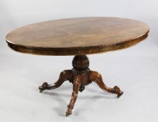 A Victorian rosewood oval breakfast table, with octagonal vase shaped column and four downswept