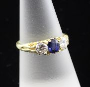An early 20th century 18ct gold, three stone sapphire and diamond ring, the oval cut sapphire