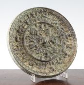 A Chinese bronze `grapevine` circular mirror, Tang Dynasty, cast in relief with tree shrews amid