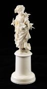 A 19th century Dieppe carved ivory figure of a young lady, with birds and chickens, on a circular