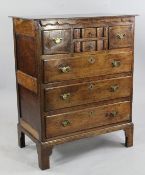 An 18th century oak chest, with two small central shaped drawers between two smaller drawers above