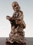 A Chinese rootwood carving of a luohan, 18th century, the figure holding a bowl, carved from the