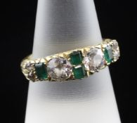 An 18ct gold, emerald and diamond half hoop ring, the carved scroll shank set with four emeralds